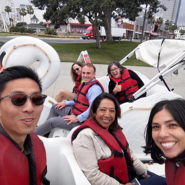 Group of people on swan-shaped paddle boats wearing life jackets